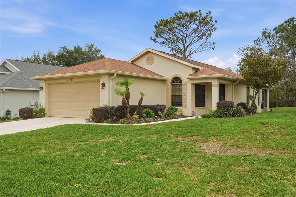 11437 Deercroft Court Spring Hill, FL 34609 - Photo 3 of 37 a front view of a house with a yard and garage