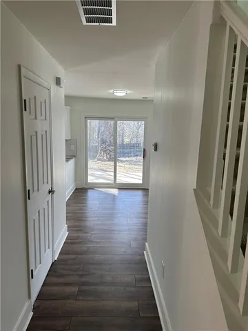 a view of a hallway with wooden floor and stairs
