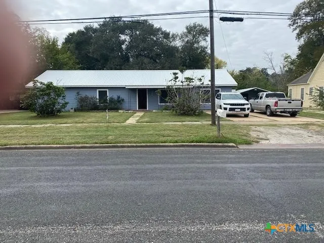 a view of a house with a yard and sitting area