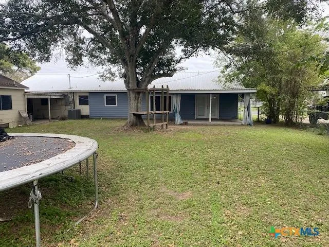 a front view of a house with a garden and trees