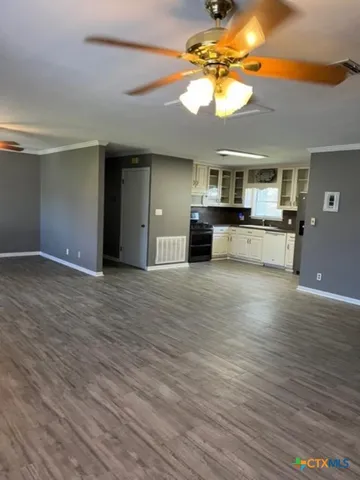 a view of living room with kitchen island furniture and a flat screen tv