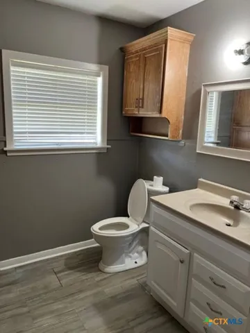 a bathroom with a toilet sink and mirror