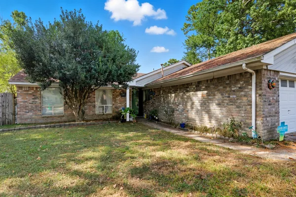 a view of a house with a large tree and a yard