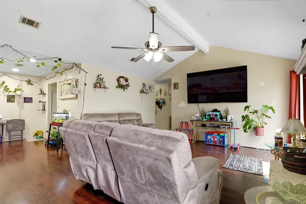 a living room with furniture a flat screen tv and a chandelier