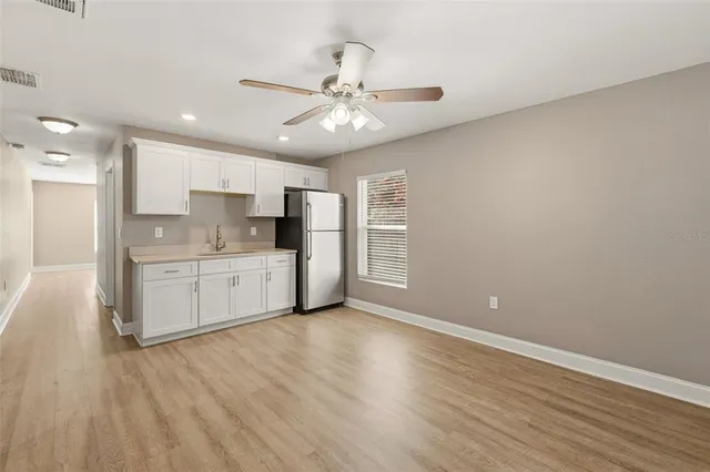 a view of a kitchen with a sink cabinets and wooden floor