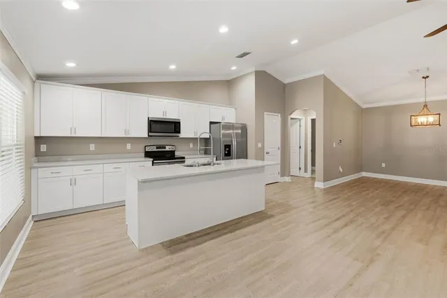 a kitchen with granite countertop a stove a sink and a refrigerator