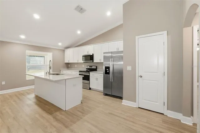 a kitchen with a refrigerator and a sink