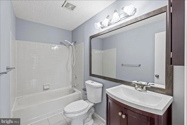 a bathroom with a sink a toilet a mirror and shower