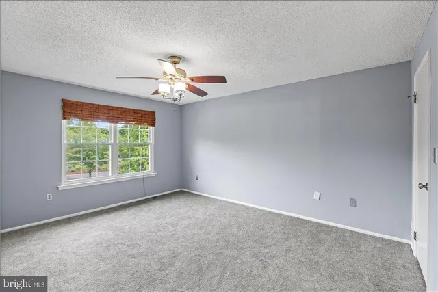 a view of a room with a ceiling fan and a window