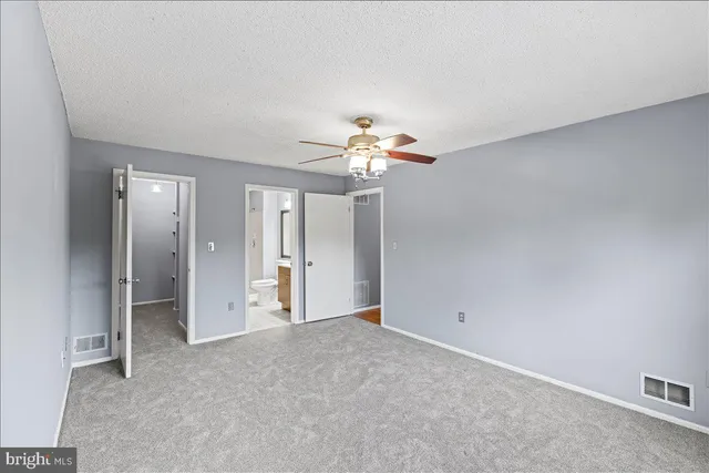 a view of an empty room with a chandelier fan