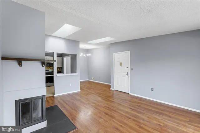 a view of a kitchen with wooden floor and a refrigerator
