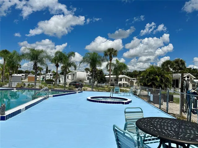 a view of a patio with swimming pool fire pit and chairs