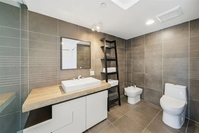 a bathroom with a sink a toilet and a mirror