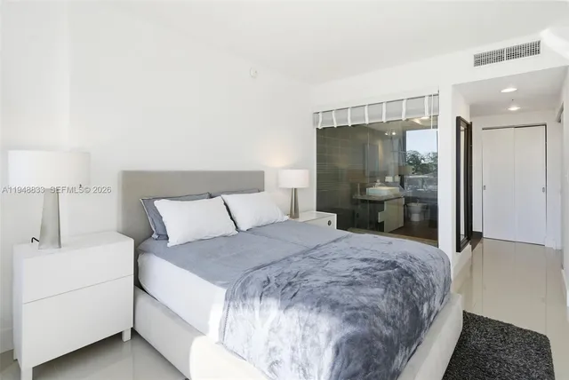 a bedroom with a bed and a large mirror