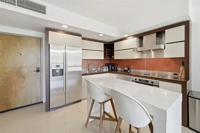 a kitchen with stainless steel appliances a refrigerator and a stove top oven