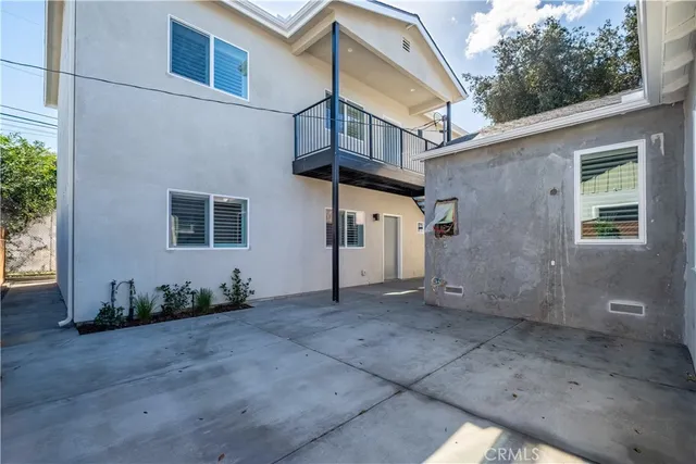 a view of a house with a small yard and potted plants