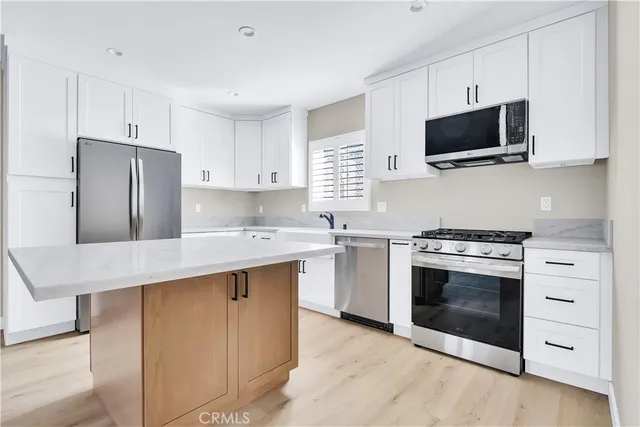 a kitchen with stainless steel appliances a stove microwave and refrigerator
