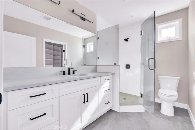 a spacious bathroom with a double vanity sink a toilet and a shower