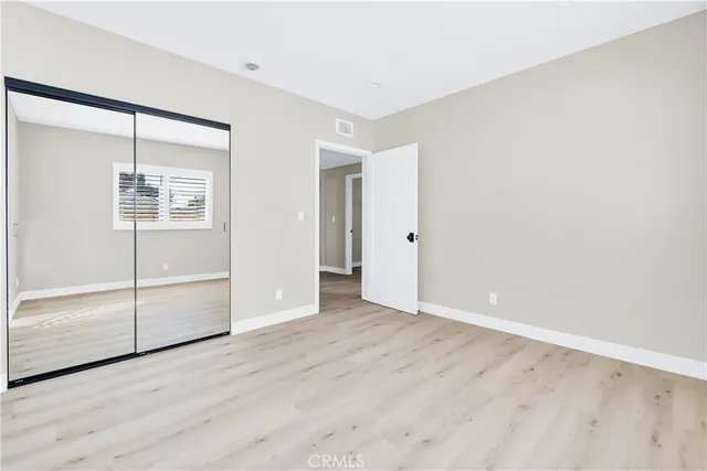 an empty room with wooden floor and door