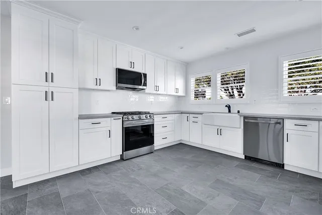 a large white kitchen with white cabinets and white appliances