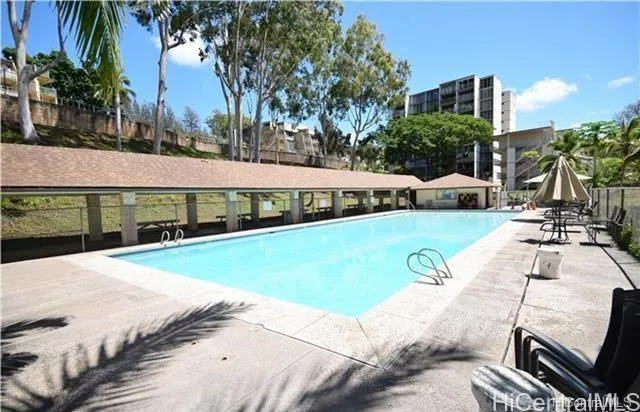 a view of a swimming pool with lawn chairs and a big yard