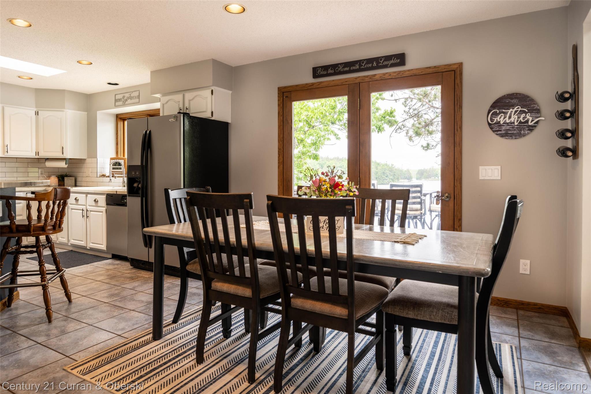 8775 Winding Rdg Drive Millersburg, MI 49759 - Photo 14 of 53 Kitchen and dining area featuring tile flooring, white cabinetry, a built-in refrigerator, and double glass doors opening to the exterior