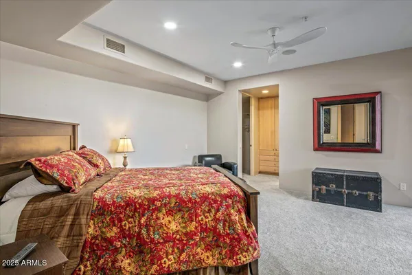 a bedroom with a large bed and a chandelier