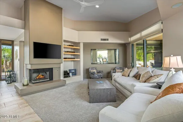a living room with furniture a fireplace and a flat screen tv