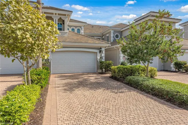 a view of a house with a yard and potted plants