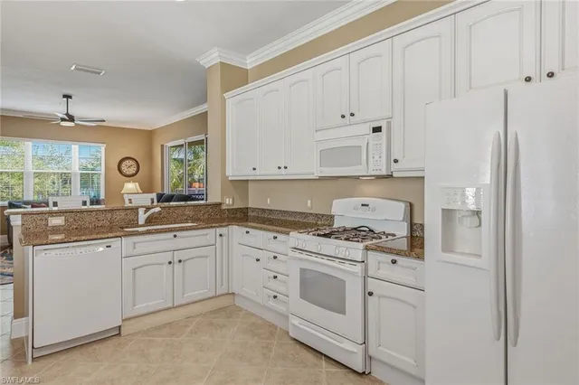 a kitchen with white cabinets and white appliances