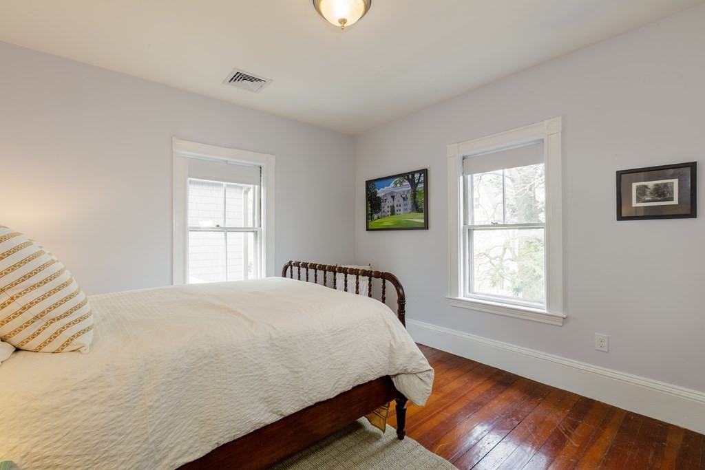 181 Willow Avenue Somerville, MA 02144 - Photo 19 of 31 a bedroom with a bed and wooden floor