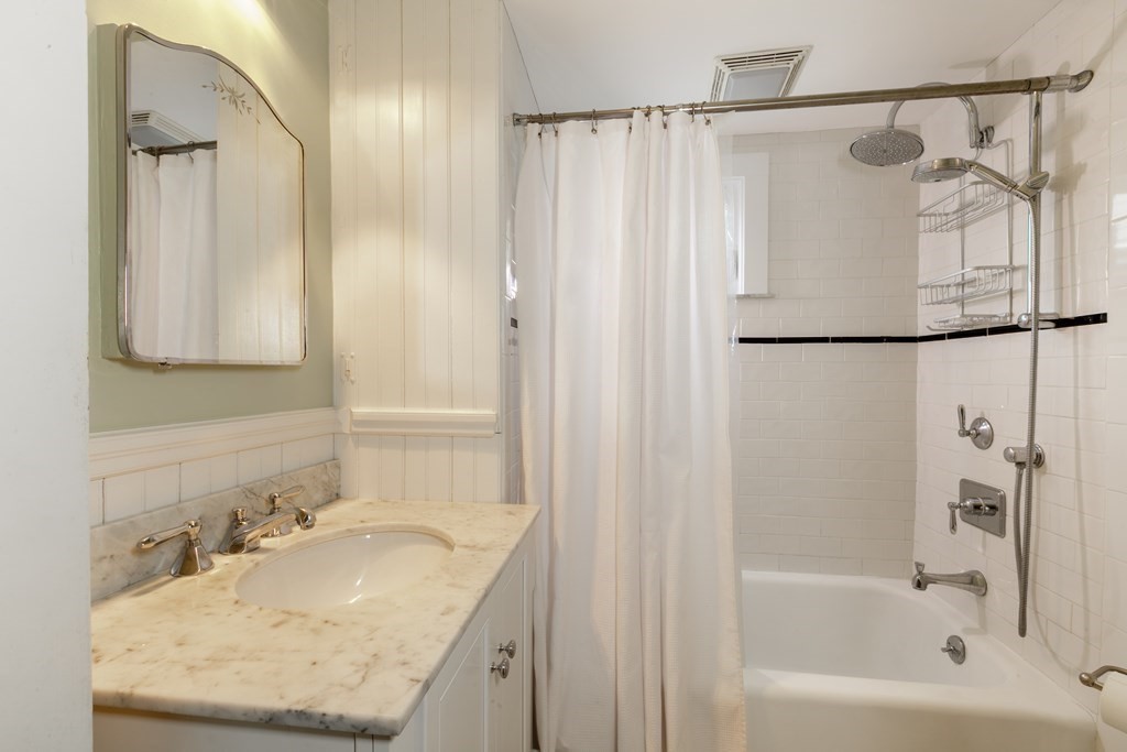 181 Willow Avenue Somerville, MA 02144 - Photo 21 of 31 a bathroom with a granite countertop sink a shower and a mirror