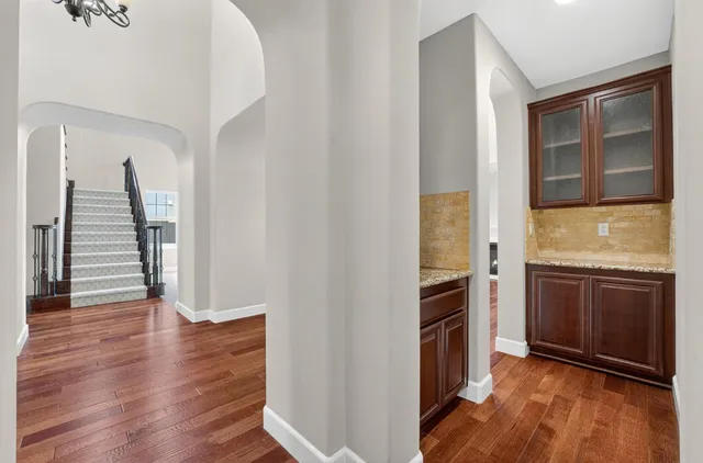 a large kitchen with stainless steel appliances granite countertop a large stove a sink dishwasher a microwave oven and a refrigerator with wooden floor