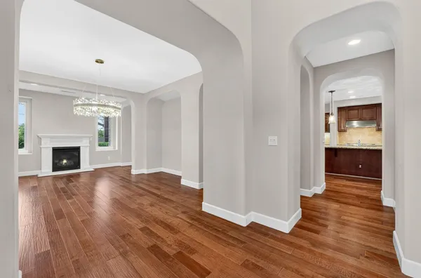 a large kitchen with stainless steel appliances wooden floor and wooden cabinets