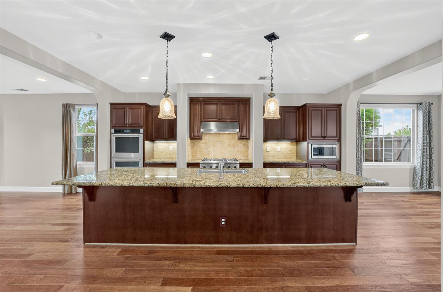 2050 Impressionist Way El Dorado Hills, CA 95762 - Photo 23 of 83 a large kitchen with granite countertop a large counter top space a sink stainless steel appliances and cabinets