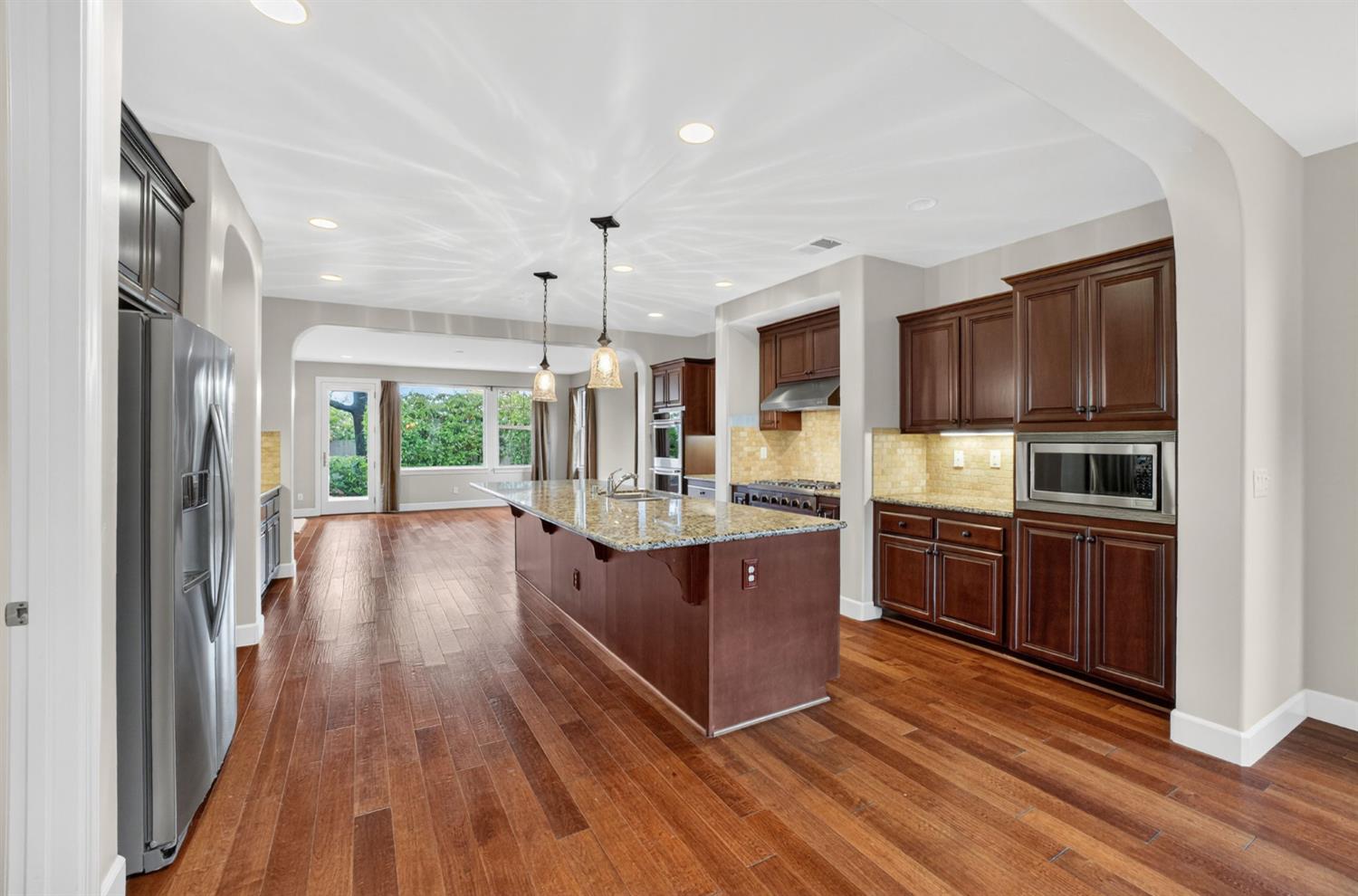 2050 Impressionist Way El Dorado Hills, CA 95762 - Photo 24 of 83 a large kitchen with stainless steel appliances granite countertop a large stove a sink dishwasher a microwave oven and a refrigerator with wooden floor