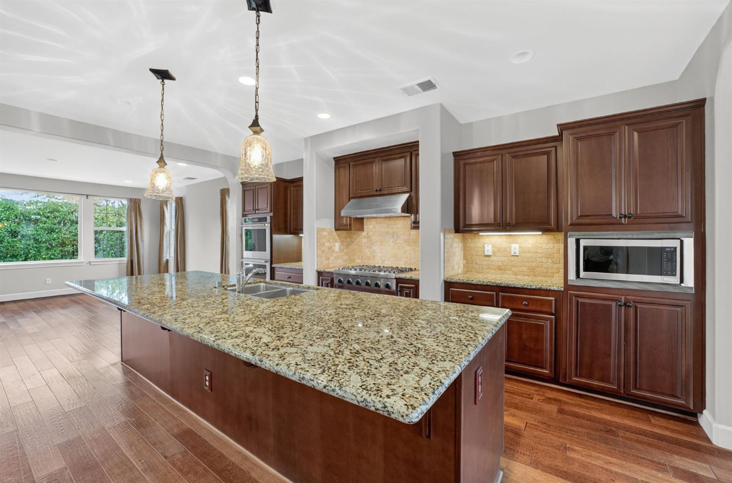 2050 Impressionist Way El Dorado Hills, CA 95762 - Photo 3 of 83 a kitchen with kitchen island granite countertop wooden cabinets and a granite counter tops