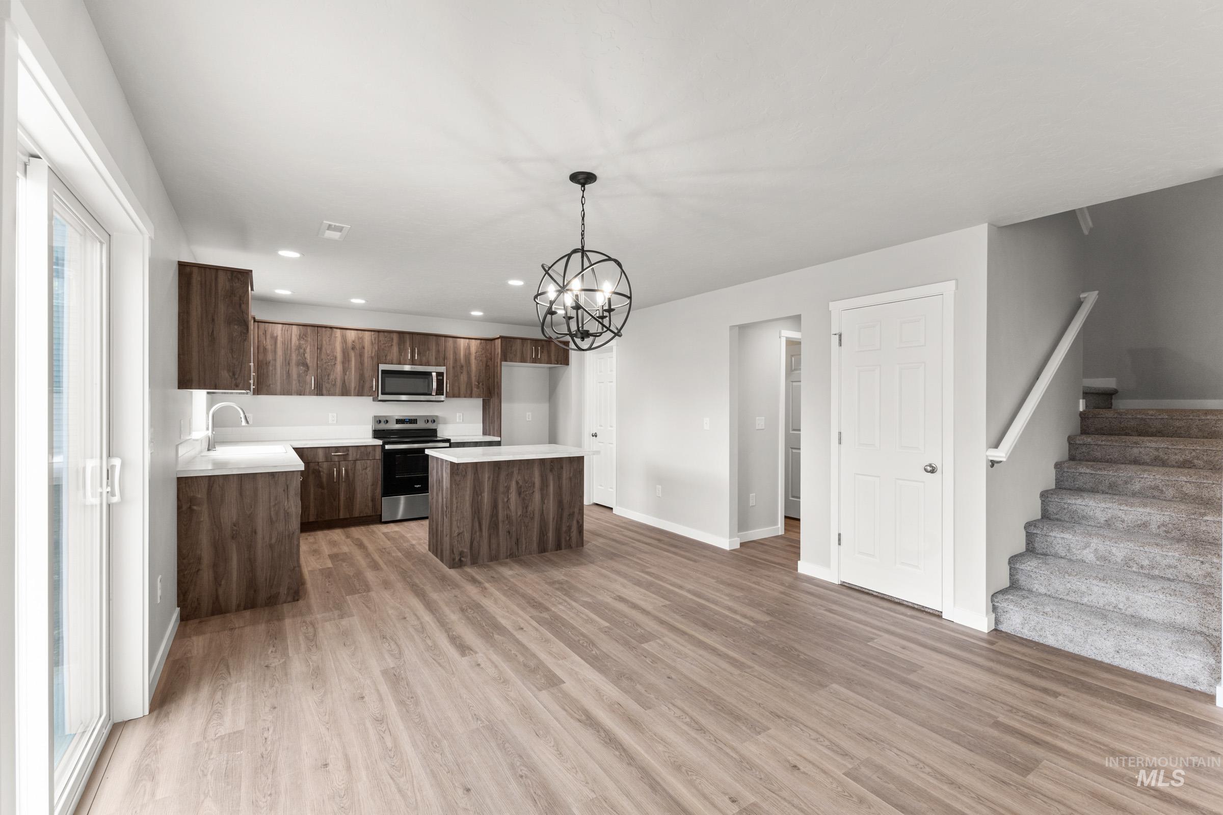 461 Waverly Avenue Middleton, ID 83644 - Photo 6 of 22 Kitchen featuring light countertops, stainless steel appliances, a center island, a chandelier, and light wood-type flooring