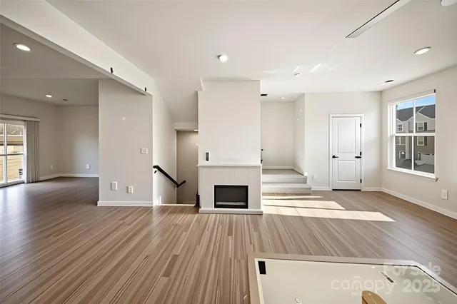 an empty room with windows and fireplace