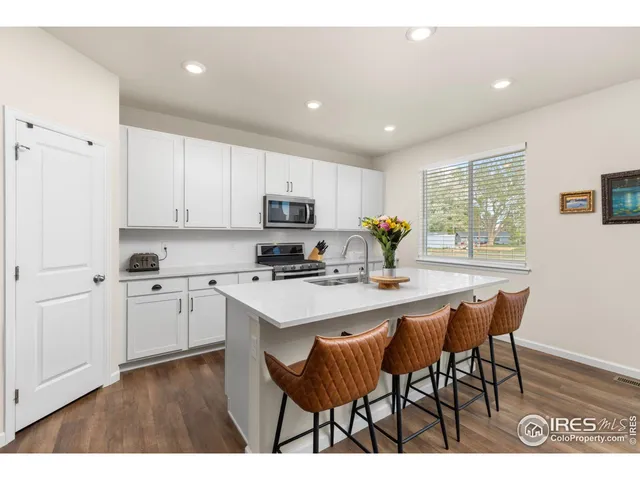 a kitchen with appliances a sink a table and chairs in it