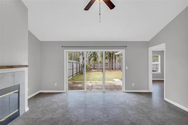 a view of an empty room with a fireplace and a window