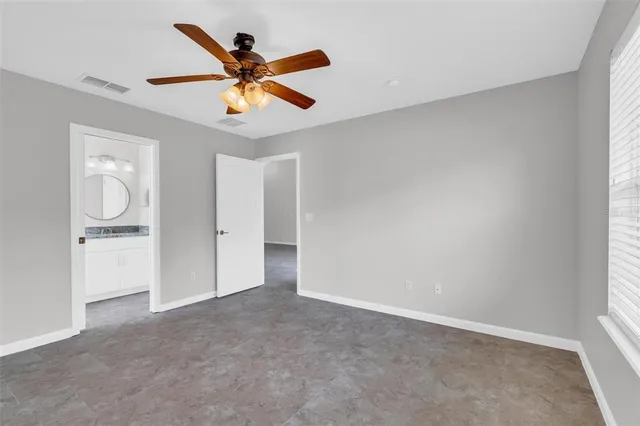 an empty room with closet and ceiling fan