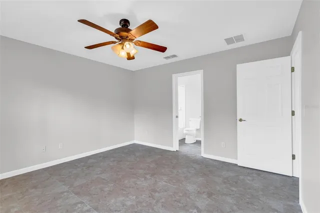 an empty room with ceiling fan and window