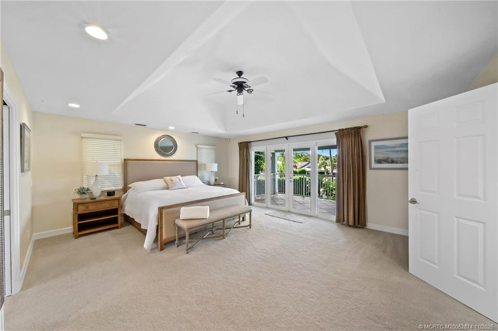 7 Island Road Stuart, FL 34996 - Photo 23 of 67 a spacious bedroom with a bed and a chandelier