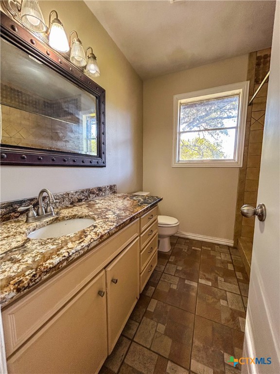 902 Joplin Street Victoria, TX 77904 - Photo 29 of 43 a bathroom with a granite countertop sink a toilet and a mirror