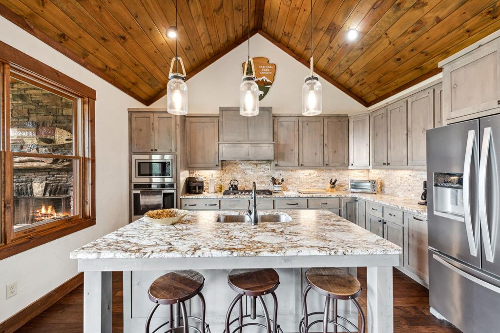370 High Ridge Road Epworth, GA 30541 - Photo 21 of 61 a kitchen with stainless steel appliances granite countertop a dining table chairs refrigerator and cabinets