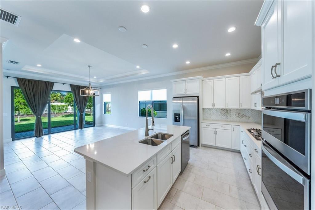 14756 Kingfisher Loop Naples, FL 34120 - Photo 2 of 16 a large white kitchen with a large window