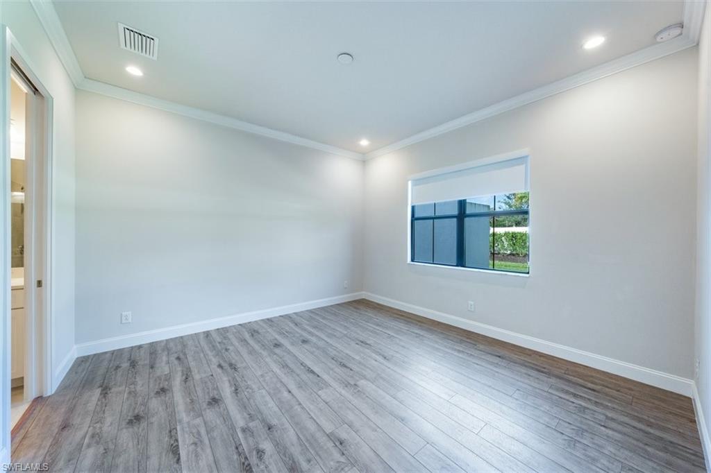 14756 Kingfisher Loop Naples, FL 34120 - Photo 6 of 16 an empty room with wooden floor and windows