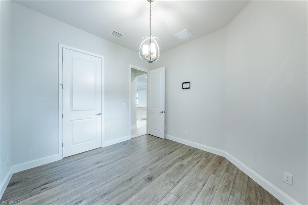 14756 Kingfisher Loop Naples, FL 34120 - Photo 10 of 16 a view of an empty room with wooden floor and a window
