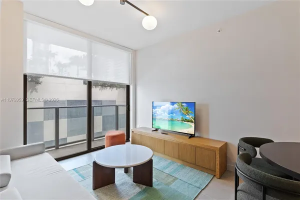 a living room with furniture a window and a flat screen tv